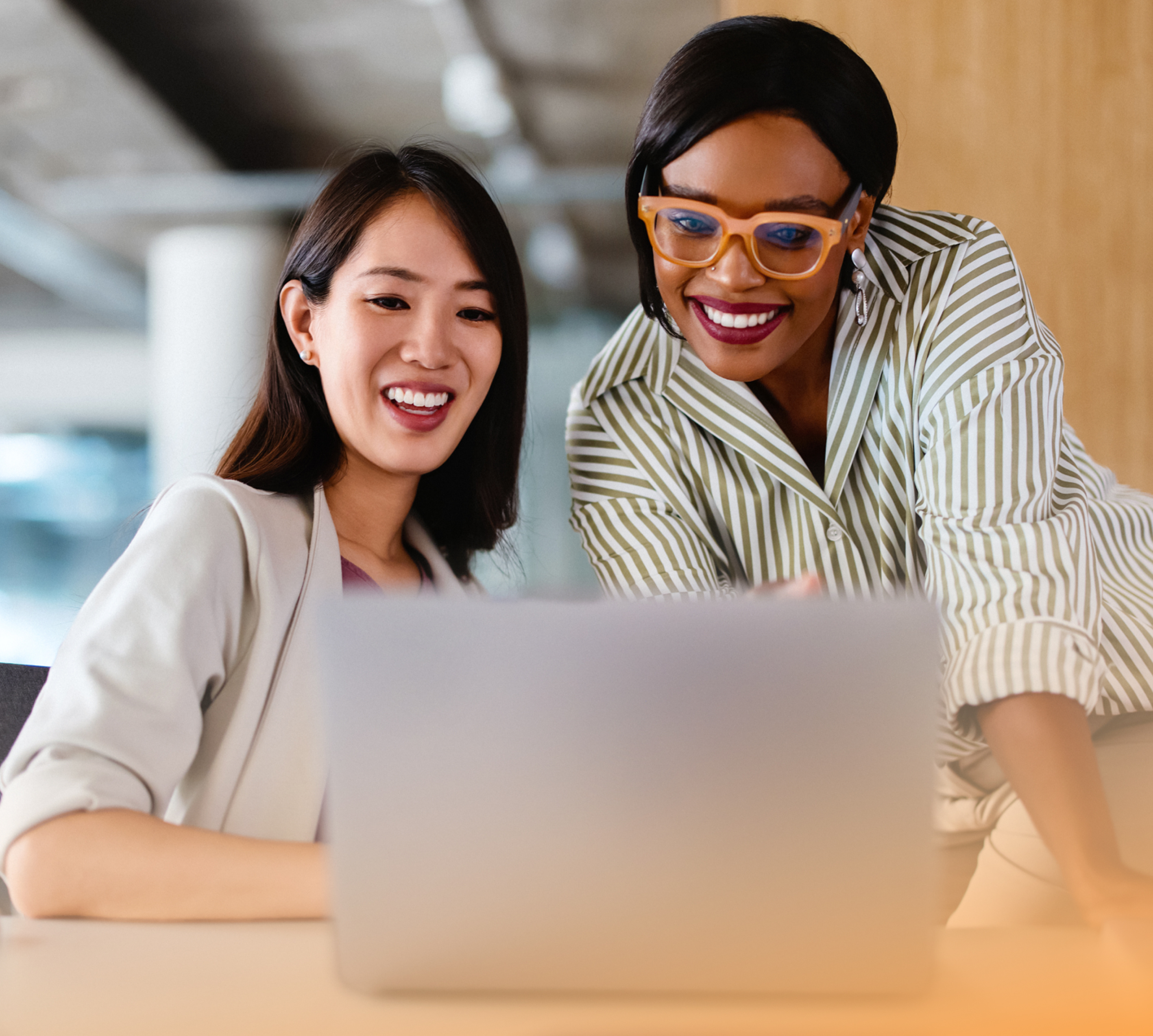 a group of women looking at a laptop