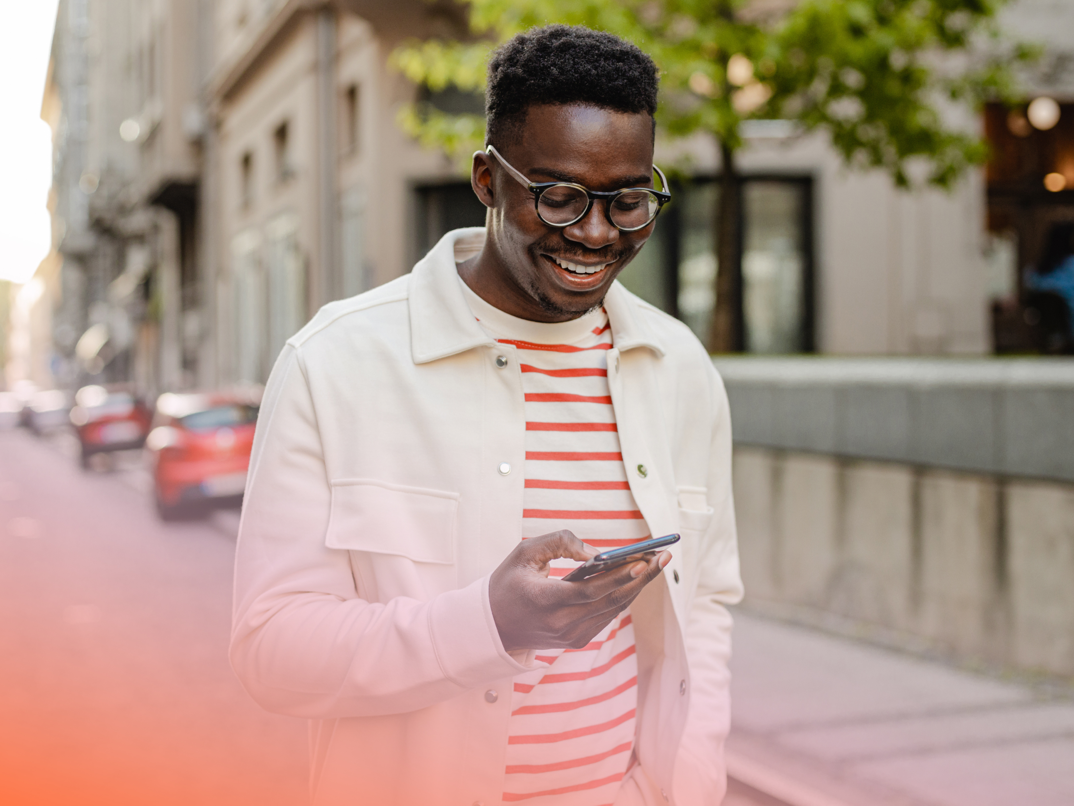 a person smiling while looking at his phone