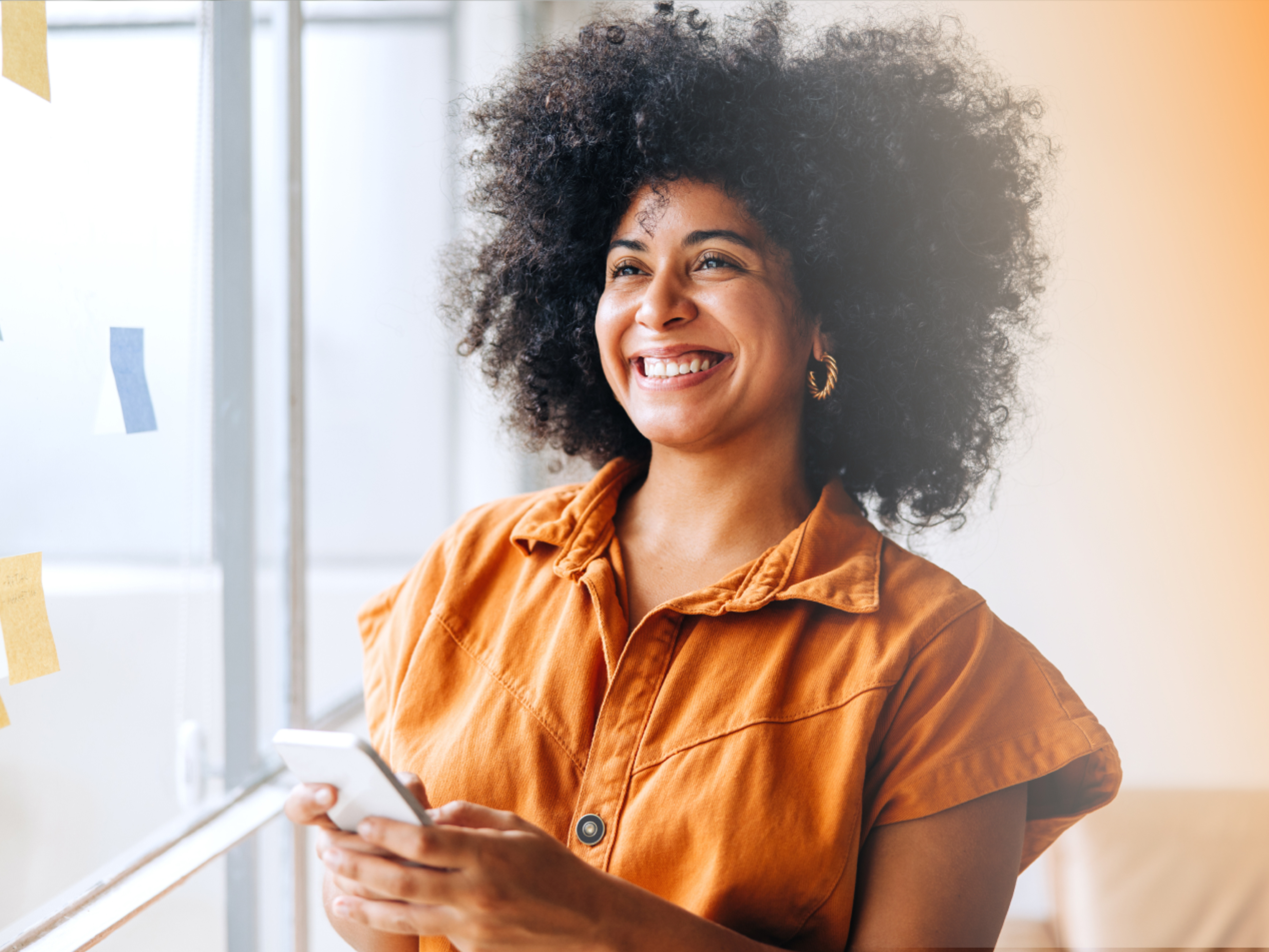 a person smiling while holding a phone