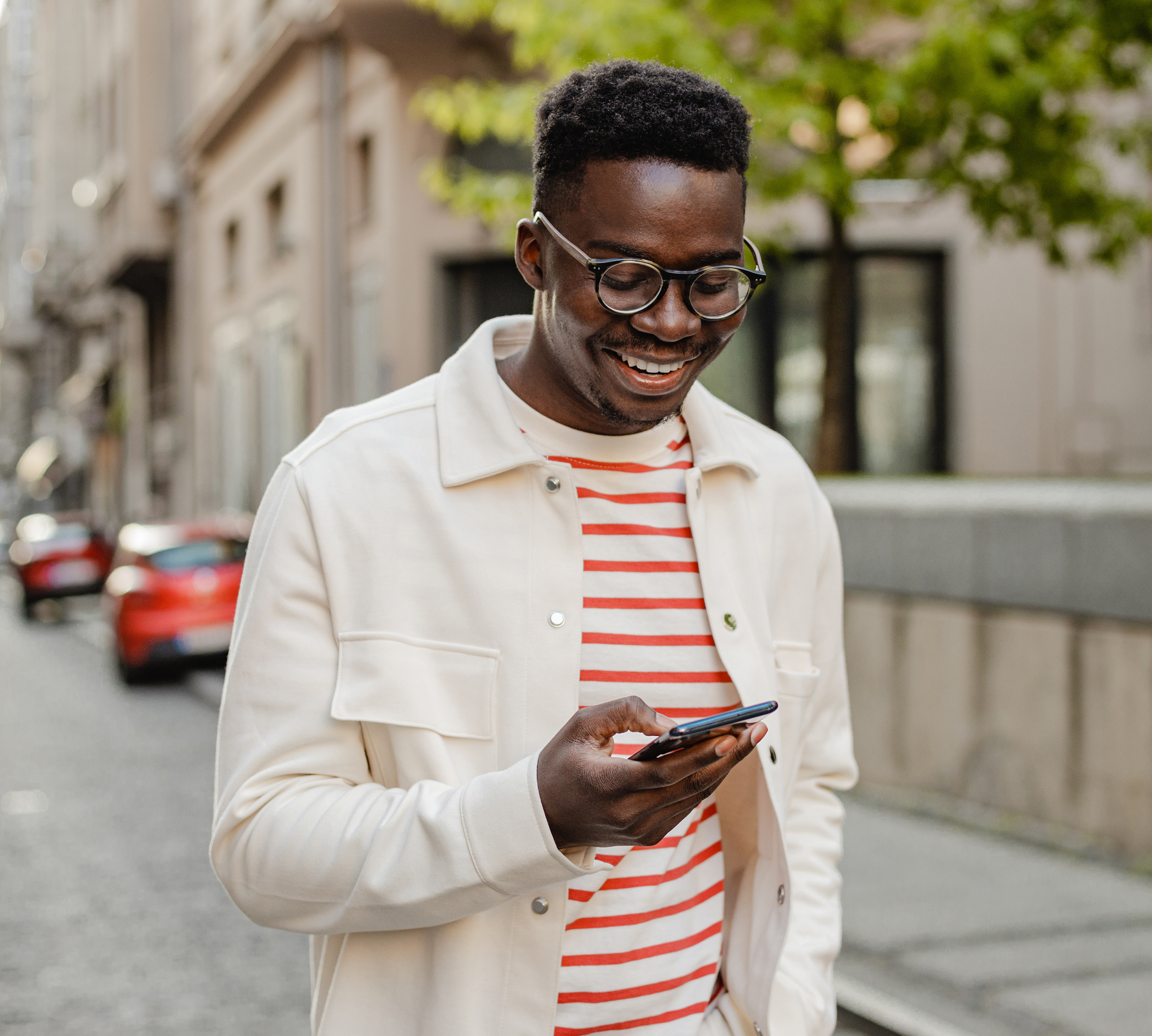 a person smiling while looking at his phone