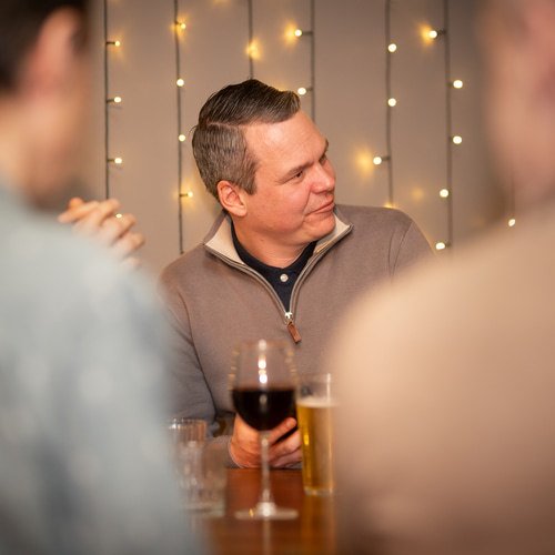 a person sitting at a table with a glass of wine