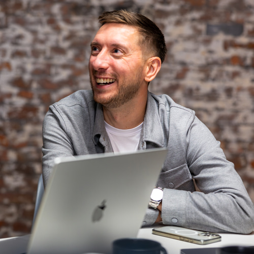 a person sitting at a table with a laptop